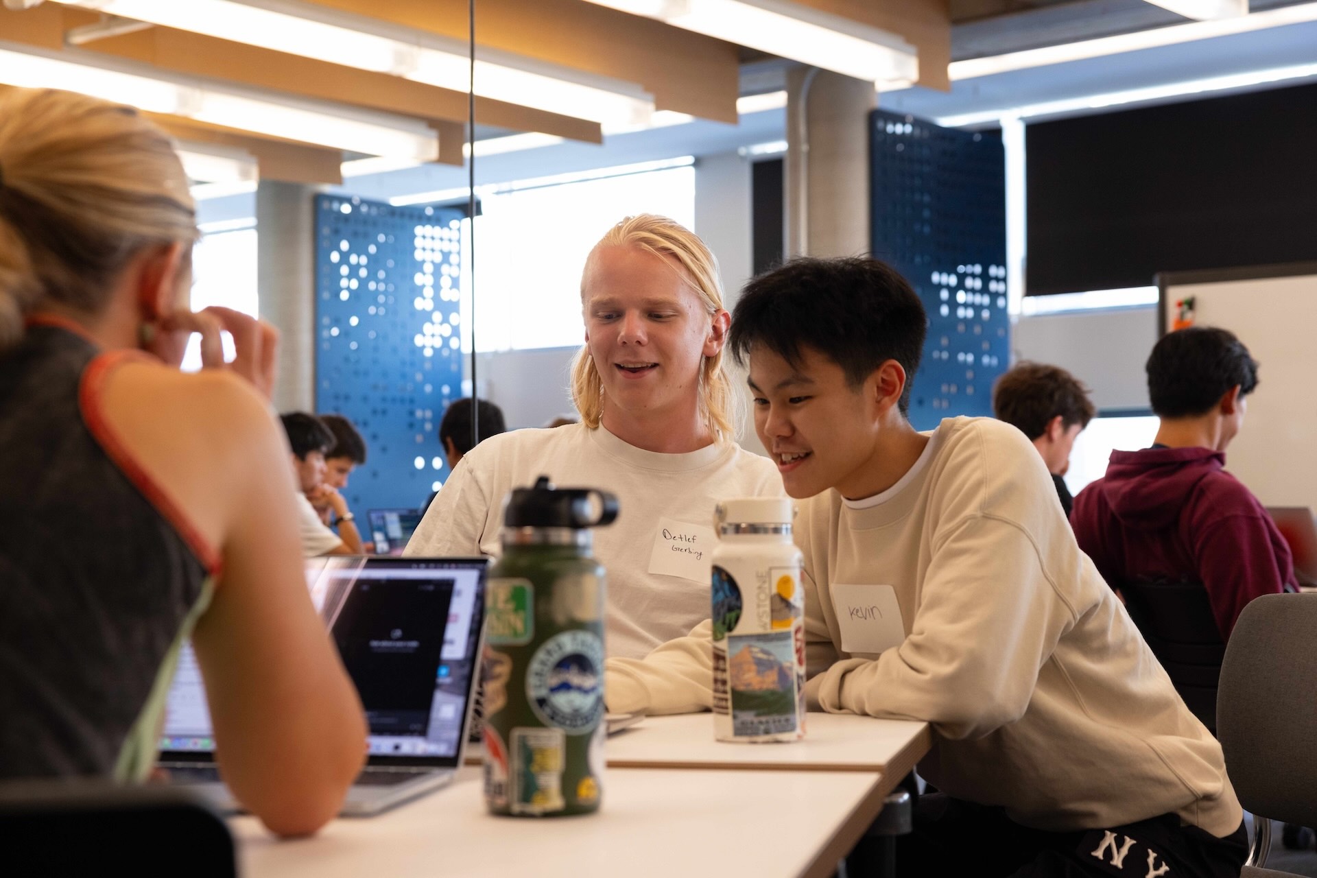 Students sitting next to eachother and talking at a table